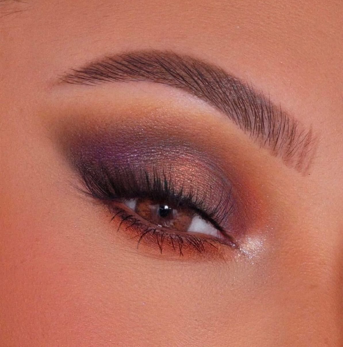 Close-up of a warm orange and purple smokey eye look using IBY Beauty eyeshadows