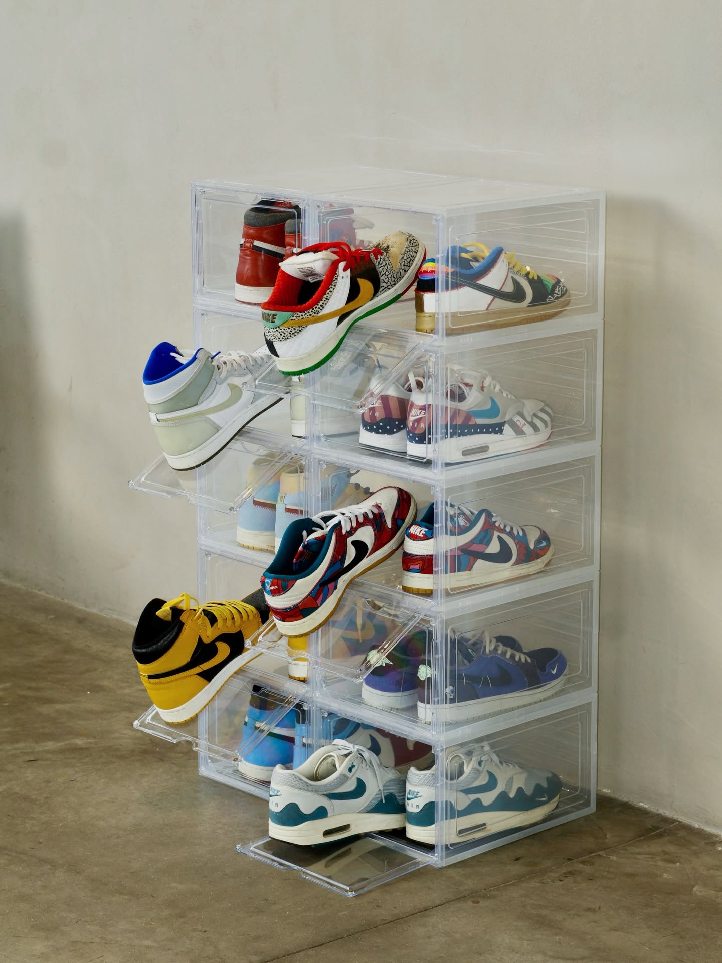 Stacked KicksBox acrylic sneaker boxes with several drop-front doors open showing sneakers