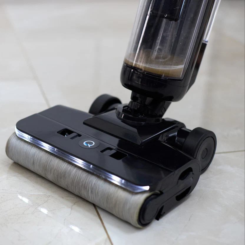 Close-up of the Quantum vacuum's brush roll picking up dust on a tile floor
